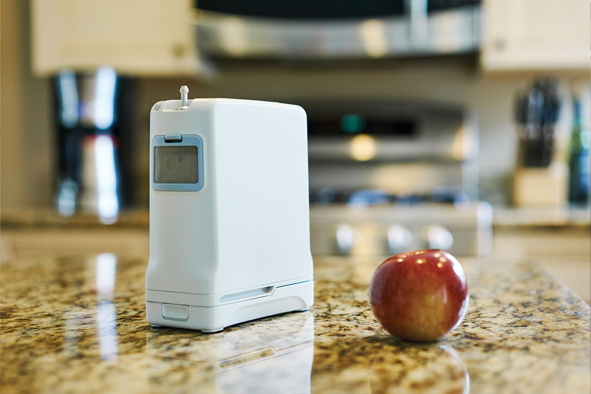 oxygen machine on a table next to an apple