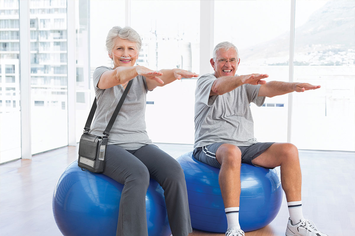 Older couple with portable oxgen machine on exercise balls