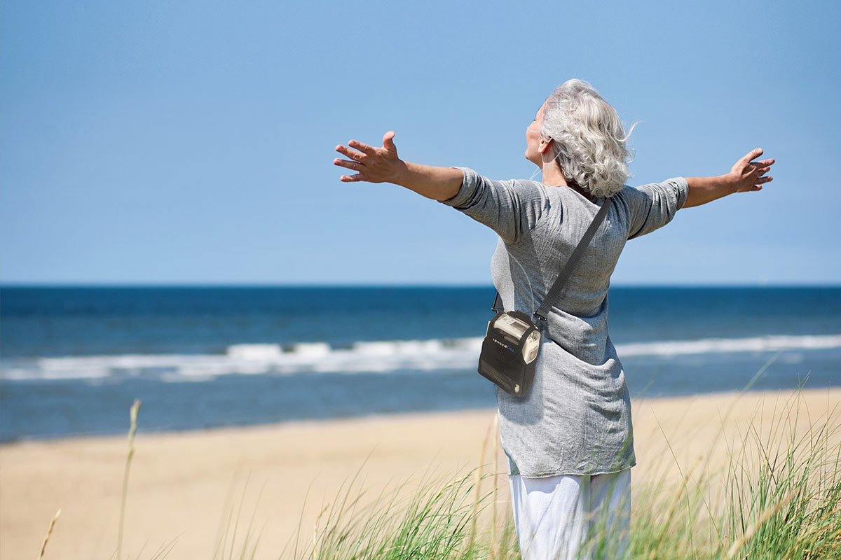 Woman on beach with arms outstretched