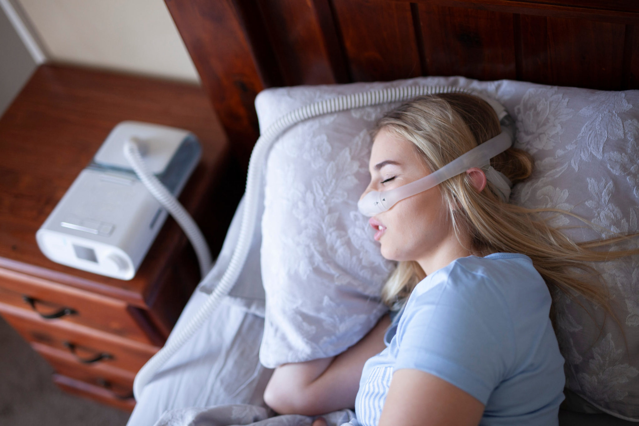 young woman sleeping whilst using a cpap machine